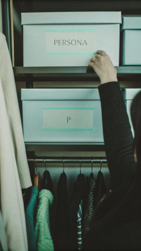 Persona organizando un armario con cajas etiquetadas.